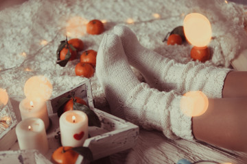 Women's legs in white knitted socks. photo in Hyugge style,