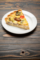 Slice of traditonal homemade spinach chicken quiche tart or pie on plate