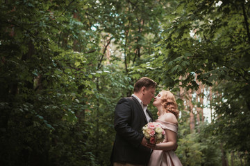 bride and groom dancing in the forest background and sunlight