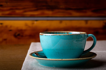 Close up blue cup and saucer on wooden background