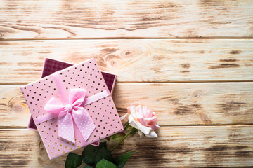 Present box and flower on wooden table.