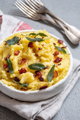 Mashed potatoes with crispy bacon and sage in a bowl