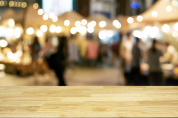 empty wood table with night street market background.