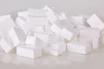 Filler packing background. Packaging foam pellets texture, top view, close-up. Polystyrene, white styrofoam packing peanuts used to prevent damage to fragile objects during shipping.