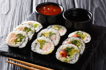 Close-up traditional Japanese rolls set served on a slate board. horizontal
