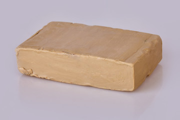 Piece of  beige plasticine clay on a white background