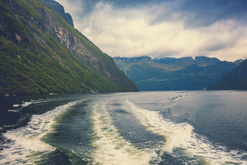 Fototapeta na wymiar Geiranger fjord. View from the ship. Mountain landscape with dramatic sky. Beautiful nature of Norway