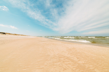 Fototapeta na wymiar Endless beach scene, calm summer landscape of nature. Blue sky and soft ocean waves. White sand on the seashore