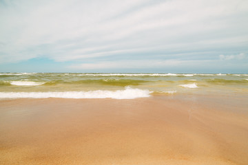 Fototapeta na wymiar Endless beach scene, calm summer landscape of nature. Blue sky and soft ocean waves. White sand on the seashore