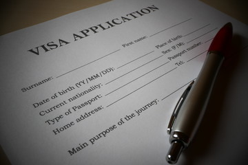 Visa application form with a pen for filling out. Document For applying to enter in a foreign country.