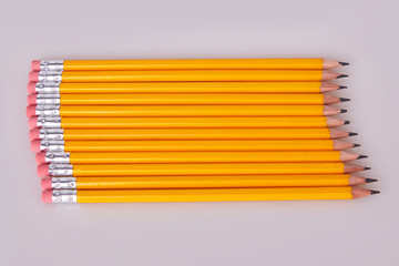 A row of pencils enter top left at an angle with erasers flush and pointing toward center....