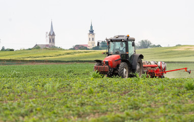 Fototapeta premium Farmer with tractor seeding soy crops at agricultural field