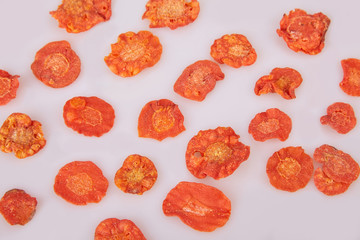 Dried carrots chips (slices) on white background. Flat lay. 