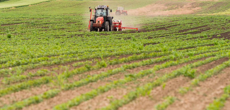  Farmer with tractor seeding soy crops at agricultural field