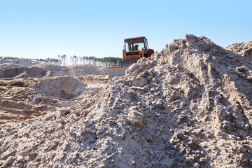 Sand quarry. Bulldozer working on sand dunes. Pure lake sand.  Old sand mining.