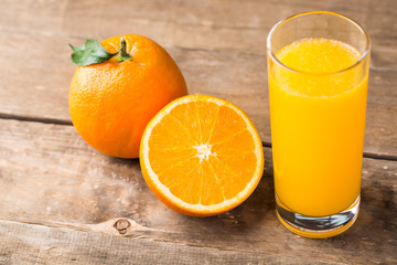 Orange juice and orange slices on wooden table