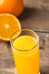 Orange juice and orange slices on wooden table