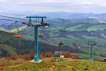 Fototapeta na wymiar Ski-lift raises tourists and athletes up and down the mountains in the Carpathians