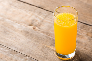 Orange juice in a glass on wooden table