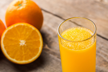 Orange juice and orange slices on wooden table