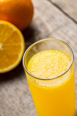 Orange juice and orange slices on wooden table