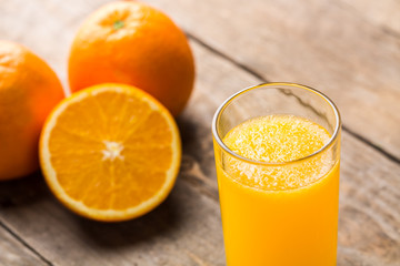 Orange juice and orange slices on wooden table