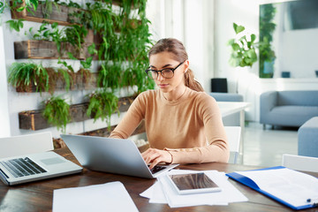 Businesswoman woring on her laptop while sitting at office desk