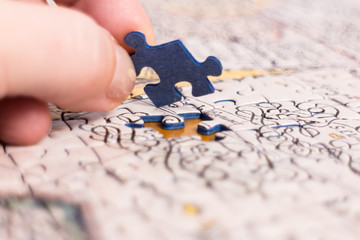 Hand put the last piece of jigsaw puzzle