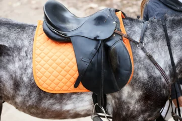 Fototapete Reiten Photo of a beautiful leather sport saddle on equestrian competition
