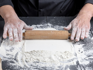 wooden rolling pin in male hands