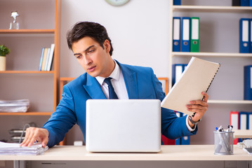 Young handsome businessman working in the office 