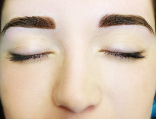 Naklejka premium Young woman with permanent eyebrows makeup, closeup