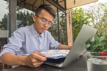 Young businessman reading financial report at outdoor space