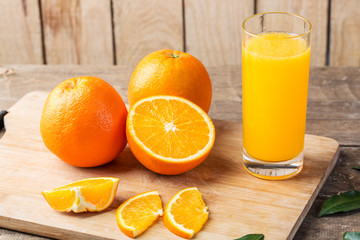 Glass of orange juice and fresh fruits on wooden background
