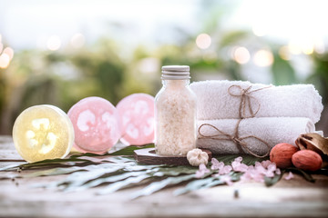 Spa handmade soap with white towels and sea salt, composition on tropical leaves, wooden background