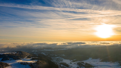 Obraz premium Aerial view of a gold sunset over winter snow.