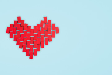 Fototapeta premium Love concept. Red heart made of toy blocks on a blue background.