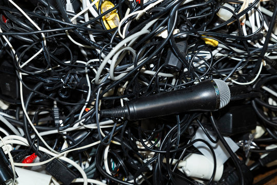 Close-up of an entangled heap of electronic scrap including a microphone waiting for recycling