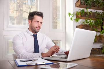 Fototapeta na wymiar Businessman working his laptop in the office
