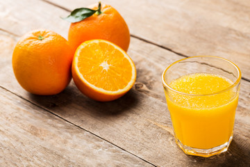 Glass of orange juice and fruits with on wooden background