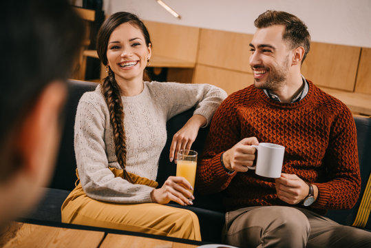 selective focus of cheerful friends holding drinks in cafe