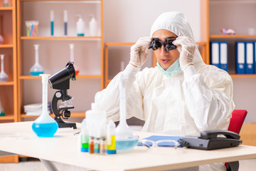 Young biochemist wearing protective suit working in the lab