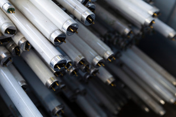 Close-up of a stack of disused and discarded neon lamp tubes waiting for recycling
