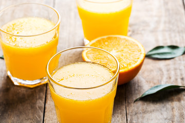 Freshly pressed orange juice, surrounded by fresh oranges