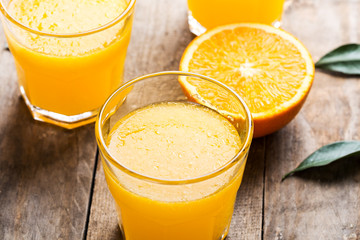 Freshly pressed orange juice, surrounded by fresh oranges