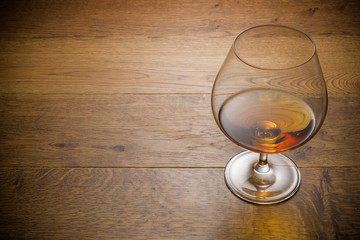 Glass of cognac and cigar with snack on the wood table with stone cutting board. Top view with copy...