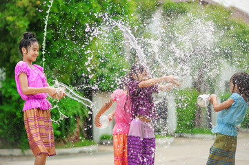 thai girls children playing water in songkran festival with thai period dress