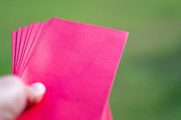 Close-up of hand young woman holding red envelopes.