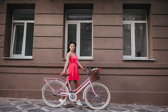 Bike and love. Happy girl in dress riding retro bicycle in the city street.