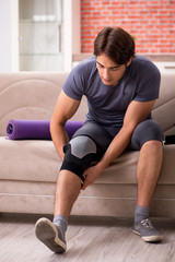 Young handsome man doing sport exercises at home 